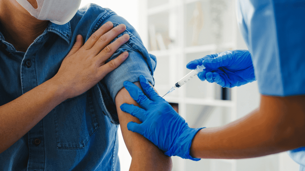 Medical assistant administering a flu shot under a licensed provider’s delegation.