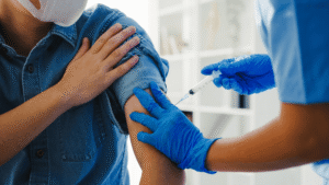 Medical assistant administering a flu shot under a licensed provider’s delegation.