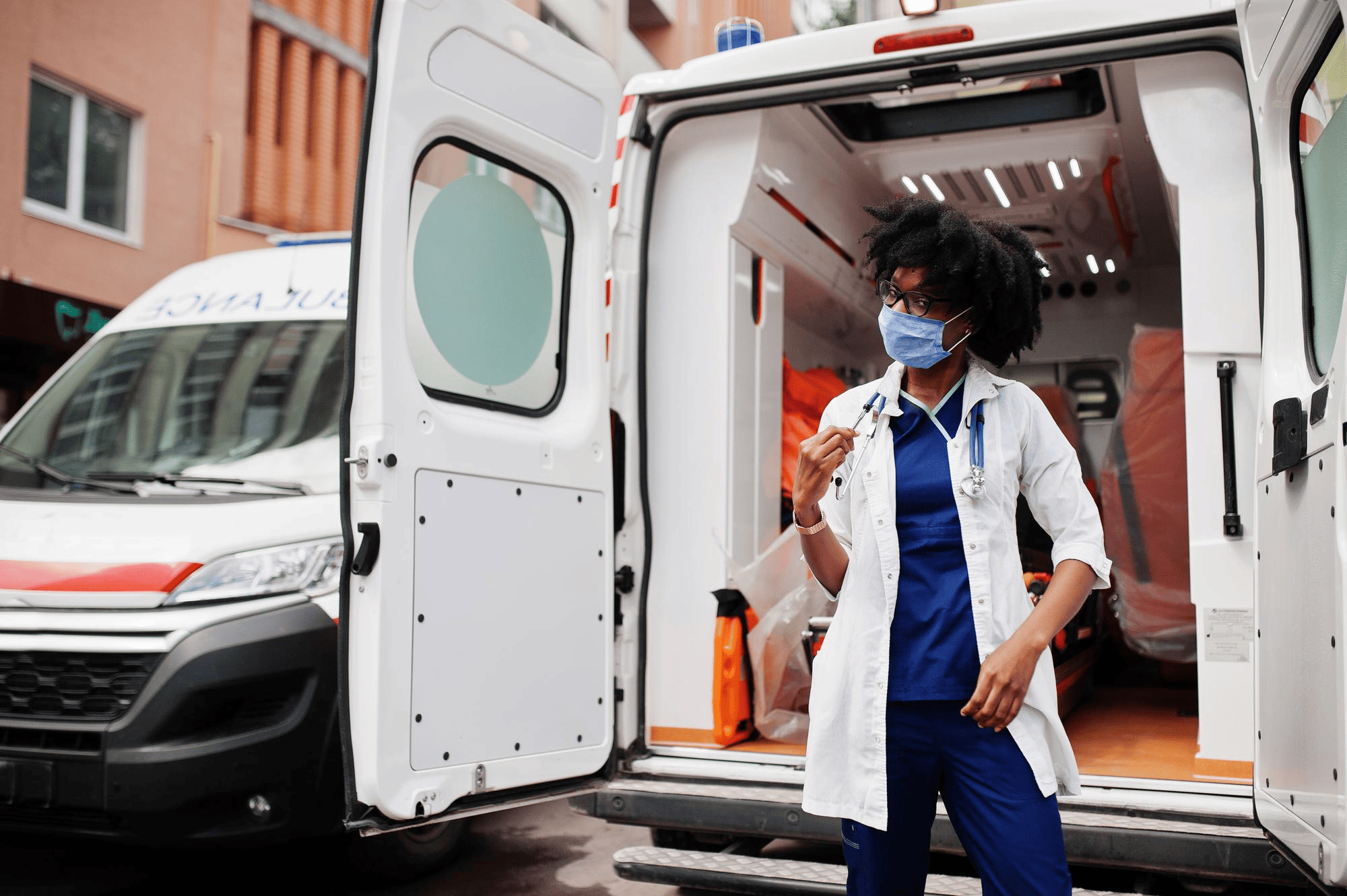Travel assistant standing next to ambulance.